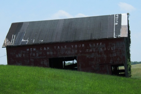 Photograph of decaying barn with religious message